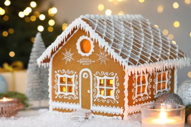 Güzel zencefilli kurabiye evi ve Noel dekoru bulanık ışıklara karşı, yakın plan. Bokeh etkisi