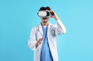 Modern teknoloji. Açık mavi arkaplanda sanal ekran kullanan kulaklıklı bir doktor