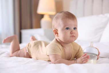 Evde yatağında biberonla beslenen tatlı bir bebek. Metin için boşluk