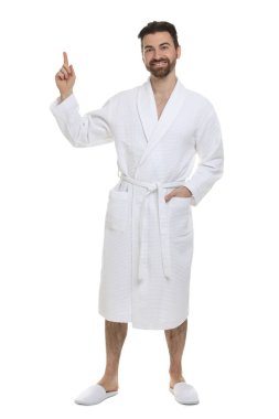 Bornozlu adam beyaz arka planda bir şeye bakıyor.