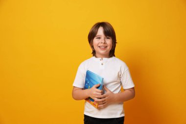 Sarı arka plan kitabı olan çocuk. Metin için boşluk