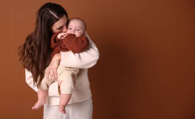 Kahverengi arka planda sevimli bebeği olan bir anne. Metin için boşluk