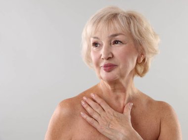 Açık gri arka planda güzel bir son sınıf öğrencisi.