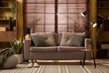 Oturma odasının içi rahat kanepe, diğer mobilyalar ve dekorlarla dolu.