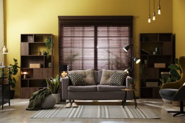 Oturma odasının içi rahat kanepe, diğer mobilyalar ve dekorlarla dolu.