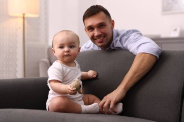 Mutlu bir baba ve sevimli bebeği evde, seçici bir odak noktası var.