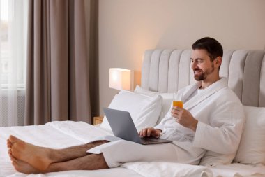 İçerde dizüstü bilgisayarla çalışan bornozlu yakışıklı bir adam. Metin için boşluk