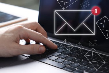Yeni e-posta bildirimi. Laptop kullanan adam, yakın plan. Ekranda uçuşan harfler