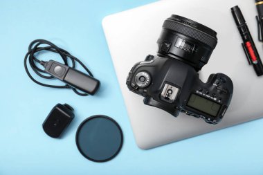 Açık mavi zemin üzerinde profesyonel fotoğrafçı ekipmanı, düz yatıyordu