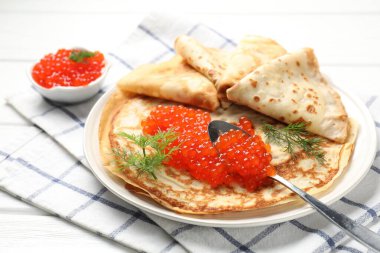 Beyaz ahşap masada kırmızı havyarlı leziz krepler, yakın plan.