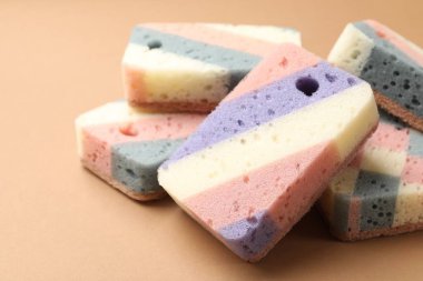 Kahverengi arka planda renkli mutfak süngerleri, yakın plan