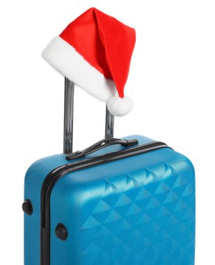 Noel tatili. Beyaz arka planda Noel Baba şapkası olan mavi bavul