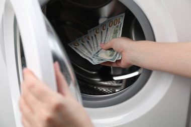 Çamaşır makinesine para koyan kadın, yakın plan.