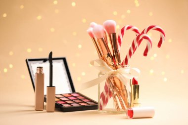 Bej arka planda makyaj ürünleri ve şeker kamışları Noel ışıkları, bokeh etkisi