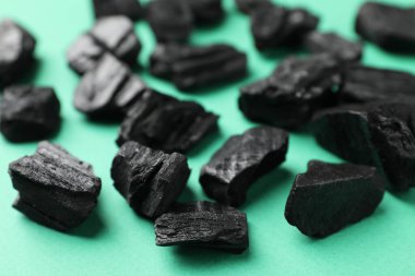 Yeşil arkaplanda siyah kömür parçaları, yakın plan