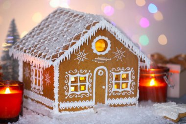 Güzel zencefilli kurabiye evi ve Noel dekoru bulanık ışıklara karşı, yakın plan