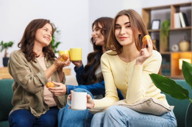 Evdeki kanepede içki ve ikramda bulunan arkadaşlar.