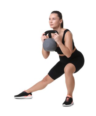 Beyaz arka planda kettlebell egzersizi yapan atletik kadın.