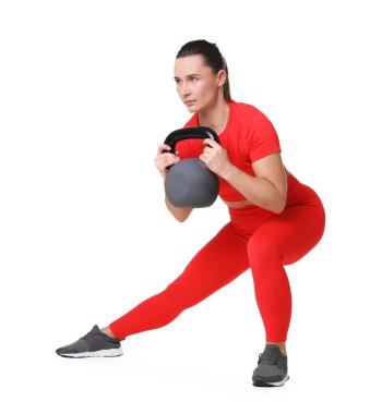 Beyaz arka planda kettlebell egzersizi yapan atletik kadın.