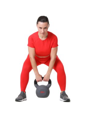 Beyaz arka planda kettlebell egzersizi yapan atletik kadın.