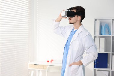 Modern teknoloji. Doktor ofiste sanal gerçeklik kulaklığı kullanıyor. Metin için boşluk