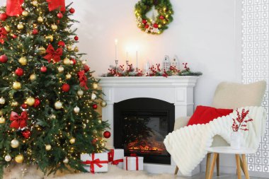 Noel ağacı, şenlikli dekor ve şömineli şık bir oda. İç tasarım