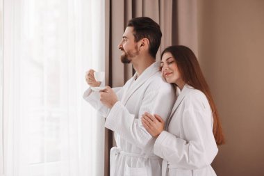 Sabahları evde kahve içen bornozlu mutlu bir çift. Metin için boşluk