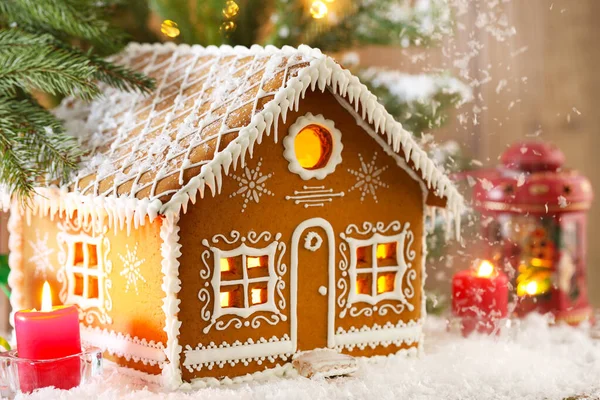 Güzel zencefilli kurabiye evi ve Noel dekoru, yağan yapay karın altında, yakın plan. Metin için boşluk