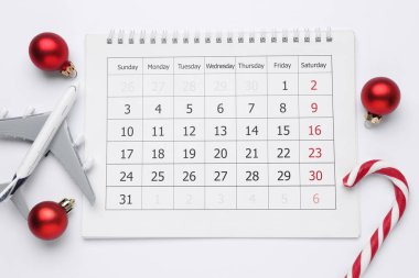 Noel tatili. Takvim, uçak modeli, baston şekerler ve beyaz arka plandaki süsler, düz konum