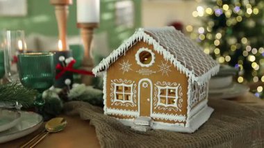 Güzel zencefilli kurabiye evi ve kapalı mekanlı Noel dekoruyla şenlik masası, yakın plan. Kamera içeri giriyor.