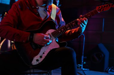 Sahnede elektro gitar çalan adam, yakın plan.