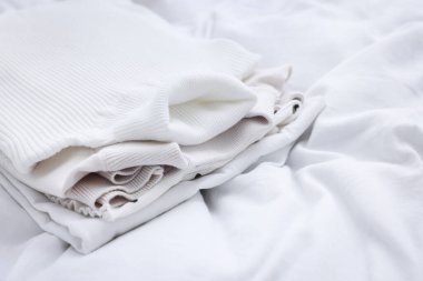 Yatakta katlanmış temiz çamaşırlar, yakın çekim manzarası.