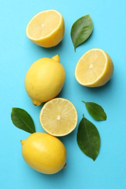 Taze olgun limonlar ve açık mavi arka planda yapraklar.