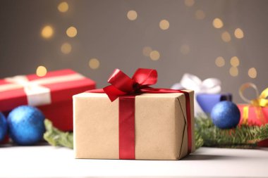 Beyaz masada bulanık ışıklara karşı Noel hediyeleri ve dekor