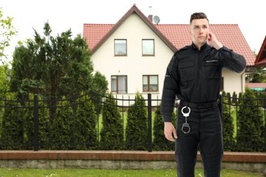 Evin yakınında üniformalı bir güvenlik görevlisi. Özel mülk koruması