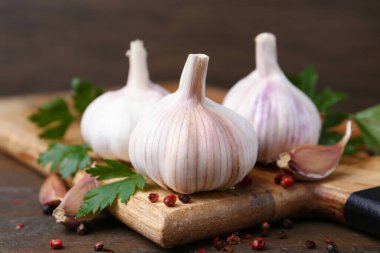 Taze sarımsak, biber ve maydanoz ahşap masada, yakın plan.