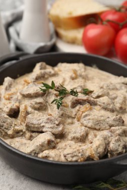 Gri masada servis edilen kekikli lezzetli Stroganoff bifteği.