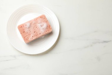 Beyaz mermer masada köpüklü ve tabaklı mutfak süngeri, üst manzara. Metin için boşluk