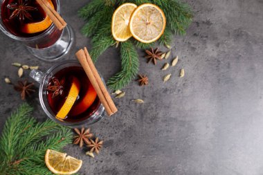 Lezzetli şarap bardaklarda, baharatlarda ve köknar dallarında gri masada, düz yerde. Metin için boşluk