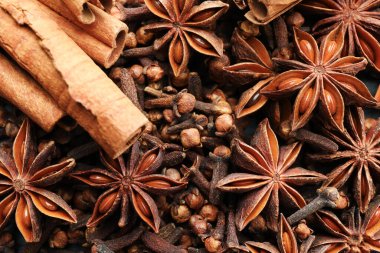 Sıcak şarap baharatları. Anise yıldızları, karanfiller ve tarçın çubukları arka plan olarak, üst görünüm