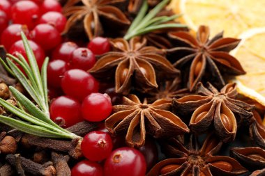 Farklı baharatlar, taze biberiye, kızılcık ve sıcak şarap için kuru portakal dilimleri, yakın plan.