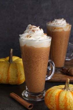 Krem şantili, baharatlı ve taze sebzeli balkabaklı latte. Koyu dokulu masa, yakın plan.