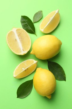 Taze taze limonlar ve açık yeşil arka planda yapraklar.