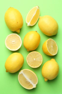 Açık yeşil zemin üzerinde taze olgun limonlar, düz uzanmış