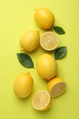 Taze olgun limonlar ve sarı arka planda yapraklar.