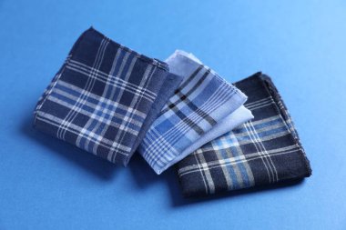 Mavi arka planda farklı tarz kumaş mendiller, yakın plan.