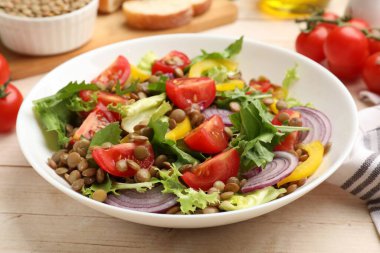 Lezzetli mercimek salatası ve malzemeler açık ahşap masada, yakın plan.