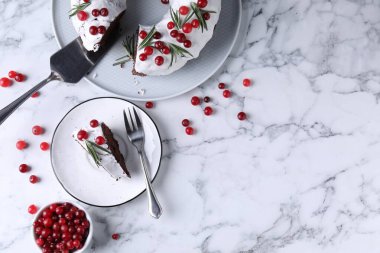 Beyaz mermer masada servis edilen yaban mersinli ve biberiyeli lezzetli Noel pastası. Metin için boşluk