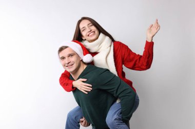 Gülümseyen çift arka planda eğleniyor. Mutlu Noeller ve mutlu yıllar.