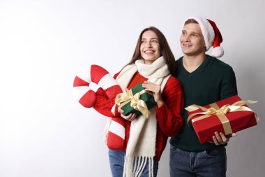 Noel hediyeli mutlu çift ve arka planda dekoratif şeker kamışı. Metin için boşluk